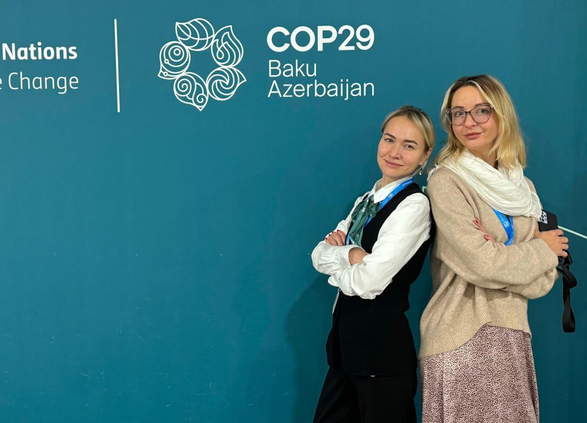Ievgeniia Kopytsia and Daryna Dvornichencko at COP29 2 women- back to back in front of COP29 logo