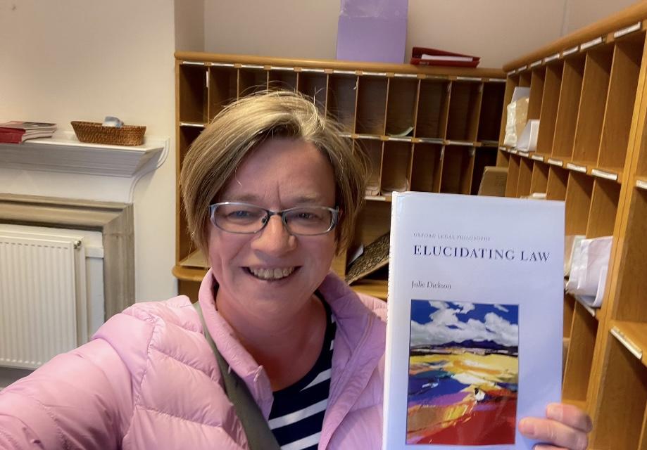 Julie Dickson holding her book - Elucidating Law Julie Dickson holding her book - Elucidating Law