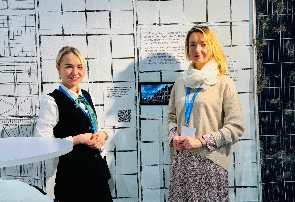 Ievgeniia Kopytsia and Daryna Dvornichencko at COP29 2 women standing in front of display materials on wall
